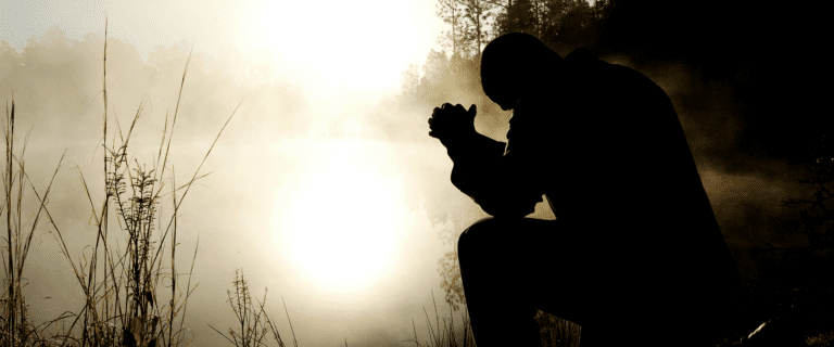 Silhouette of a man praying