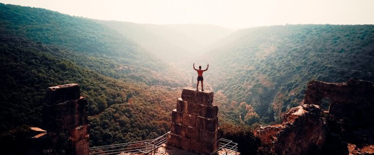 A man stands on top of blocks in front of a mountain