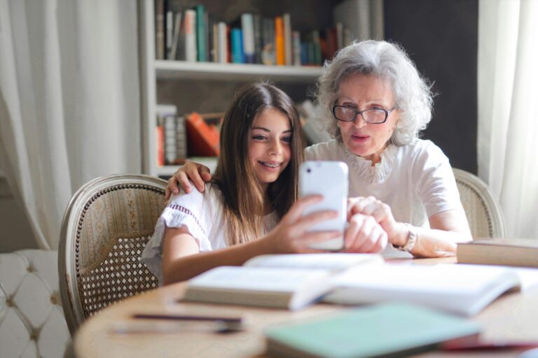 Grandmother and granddaughter looking at MY Faith Assistant - Faith AI, Bible Based AI