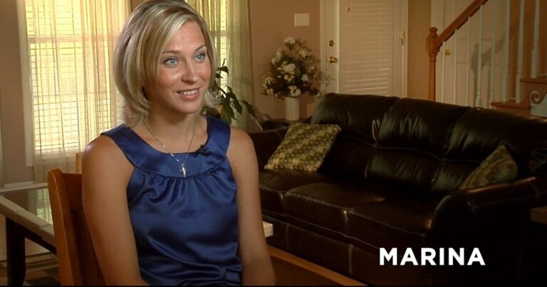 Marina sitting in a warmly lit room with her name in white bold text in the bottom-right corner